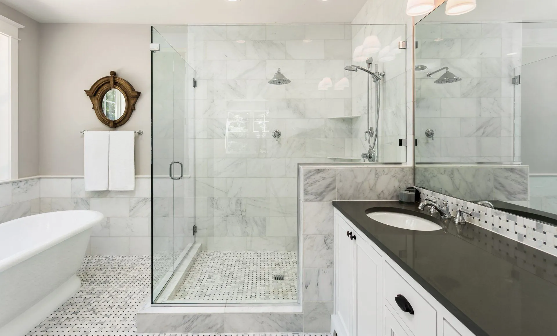 Custom frameless glass shower enclosure in a luxury marble bathroom in Vancouver